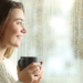 Can Pest Control be Done in the Rain? woman with hot beverage looking out the window at a rainy day